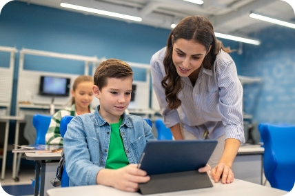 A teacher helping students with MathJam on a laptop